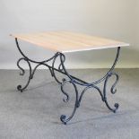 A continental limed oak table, on an iron base,