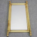 A gilt painted wooden wall mirror, with turned finials,