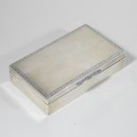 A modern silver table cigarette box, of hinged rectangular shape, with an engraved scrolled border,