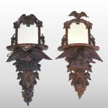 A pair of early 20th century Black Forest Style carved wall brackets, each having a mirrored back,
