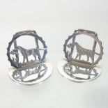 A pair of early 20th century silver menu holders, each in the form of a retriever, on a disc base,