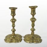 A pair of 18th century brass table candlesticks, each having a knopped stem,