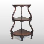 A Victorian rosewood corner whatnot, having three graduated tiers, united by scrolled supports,