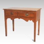 An 18th century pitch pine lowboy, containing a pair of short drawers, above a shaped apron,
