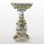 An early 20th century German porcelain figural bowl, of pedestal form, encrusted with flowers,