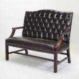 An 18th century style brown upholstered sofa, 20th century, with a studded button back,