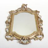 An ornate 19th century carved wood and gilt gesso framed wall mirror, the arched rectangular plate,