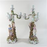 A pair of early 20th century German porcelain three branch candelabra, each encrusted with roses,