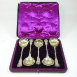 An ornate Victorian silver gilt fruit set, comprising four serving spoons, 22cm and a sifting spoon,