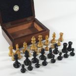 An early 20th century wooden chess set, tallest 7cm, in a walnut case,