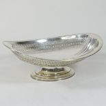 An early 20th century silver basket, of boat shape, with pierced decoration, on a pedestal foot,