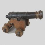 An antique cast iron desk model signal cannon, on a later wooden stand,