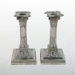 A pair of Edwardian silver table candlesticks, each in the form of a Corinthian column,