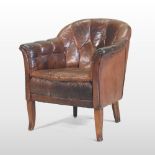 An early 20th century brown leather upholstered armchair, of tub shape, with a buttoned back,