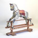An early 20th century carved wooden dappled grey rocking horse, on a pine rocker,