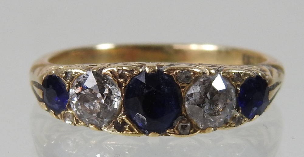 An early 20th century 18 carat gold sapphire and diamond five stone ring, with textured shoulders, - Image 4 of 4