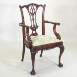 A Chippendale style carved open armchair, with a green padded seat,