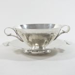 A modern silver twin handled bowl on stand, of circular shape, with hammer beaten decoration,