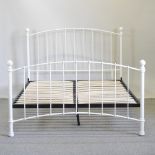 A modern white painted metal bedstead, with a slatted wooden base,