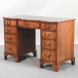 A reproduction walnut serpentine pedestal desk,