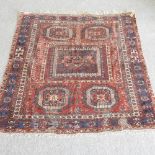 A Turkish woollen rug, with five medallions, on a red ground,