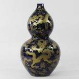 An oriental pottery blue and gilt double gourd vase,