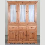 A pine glazed side cabinet, with cupboards below,