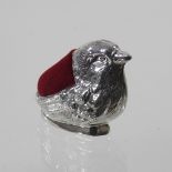 A white metal bird pin cushion,