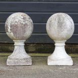 A pair of reconstituted stone gatepost finials,