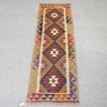 A kelim runner, with a row of four medallions, on a beige ground,