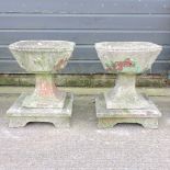 A pair of reconstituted stone square garden planters, on pedestals,