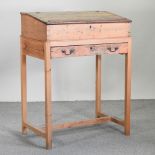 A 19th century pine clerk's desk, on a later stand,