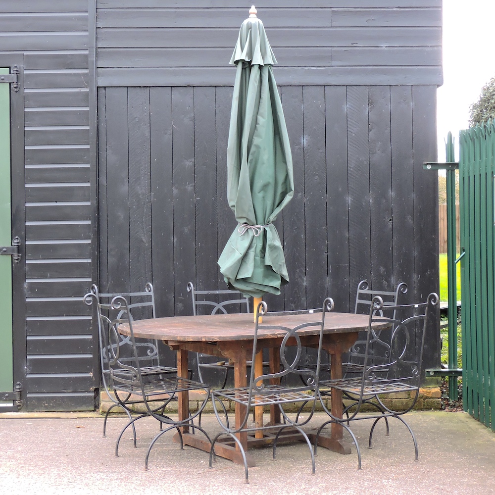A wooden oval shaped extending garden table, 171 x 120cm overall,