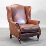 A brown leather upholstered armchair,