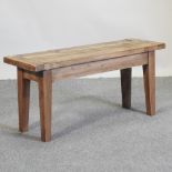 A rustic pine bench, on square tapered legs,