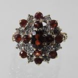 A 9 carat gold garnet and diamond cluster ring, boxed,
