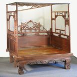 A Chinese carved wedding/opium bedstead, with pierced decoration and a carved footboard,