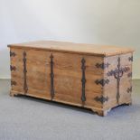 A large antique pine and iron bound chest, with a hinged lid,
