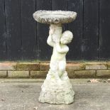 A reconstituted stone cherub bird bath,