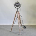 A chrome spotlight, on a teak tripod base,