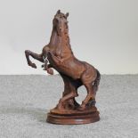 A rusted metal model of a rearing horse,