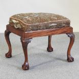 A Chippendale style footstool, on claw and ball feet,