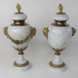 A pair of white marble urns, with gilt ram's head decoration,