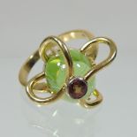 A modern 18 carat gold natural peridot and garnet cage set ladies ring,