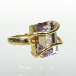 A modern 18 carat gold topaz ring, set with a baguette cut stone and having asymmetrical overlay,