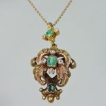 An unmarked emerald and diamond pendant necklace, of ornate scrolled design, 4cm high,