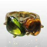 A modern 14 carat gold polished peridot and topaz two stone ring,