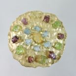 A large 18 carat gold and natural gem set brooch, of rough textured circular shape,