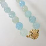 An aquamarine coloured single strand bead necklace, with a large 18 carat gold clasp,