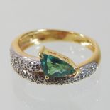 A modern 18 carat gold green tourmaline and diamond winding arrow ring,